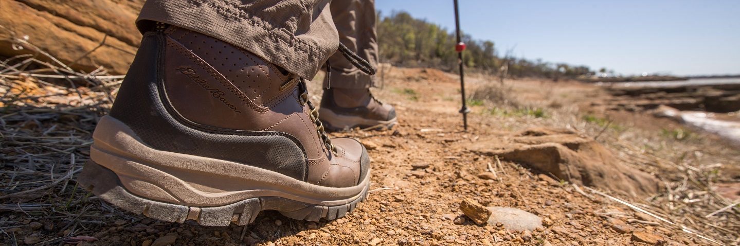 Hiking boots on a trail beside the water
